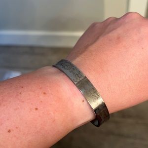 Silver sister bracelet with saying under.